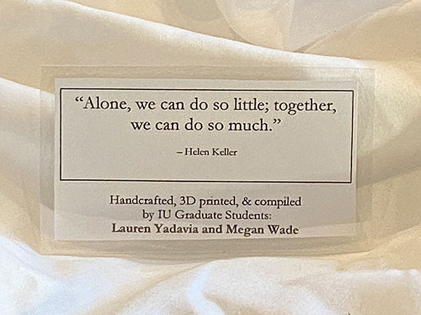 An image of the laminated message attached to the PPE the students distribute. The message reads, "Alone, we do so little; together, we can do so much." ~ Helen Keller