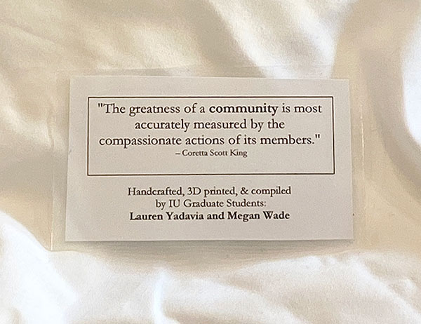 An image of the laminated message attached to the PPE the students distribute. The message reads, "The greatness of a community is most accurately measured by the compassionate actions of its members" ~ Coretta Scott King